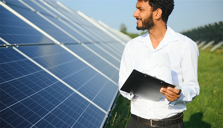 Man stood in front of solar panels